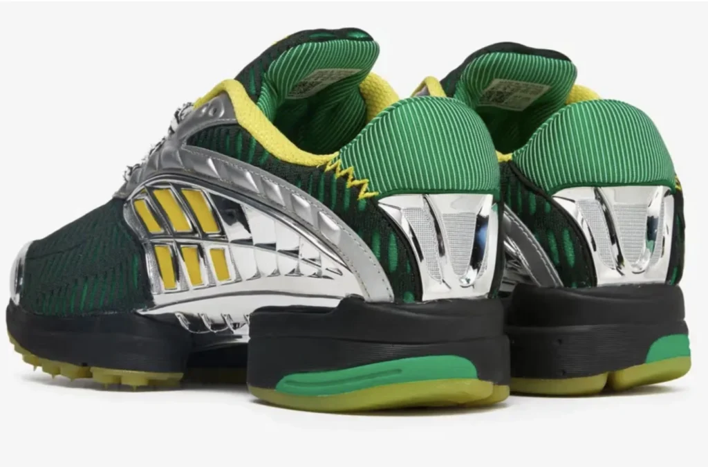 Rear view of the Brain Dead x adidas Climacool 2 sneakers in green, yellow, and chrome. The shoes feature metallic silver midfoot cages with yellow inserts, ribbed green textile uppers, and padded yellow interiors. The sculpted black midsoles transition into translucent green outsoles, highlighting the shoe’s futuristic, ventilated design inspired by early-2000s adidas performance runners.