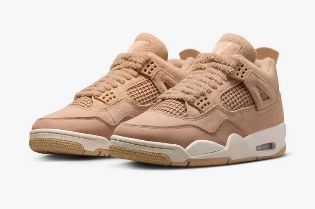 Air Jordan 4 WMNS “Cozy Girl” sneakers in Hemp and Light Orewood Brown, featuring hairy suede uppers, fuzzy laces, and cream midsoles with gum outsoles, displayed angled to show texture and construction on a white background.
