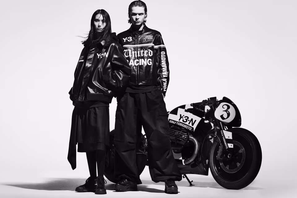 Close-up of Y-3 × NEIGHBORHOOD Fall/Winter 2025 capsule collection showcasing black leather biker jacket with metallic detailing and embossed Y-3 × NEIGHBORHOOD logos under studio lighting.