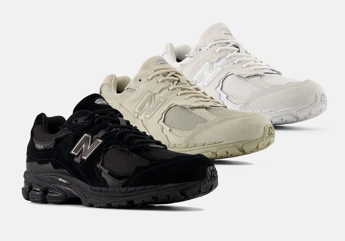 Three pairs of New Balance 2002R sneakers from the Protection Pack in black, beige, and off-white colorways, displayed side by side on a light background.