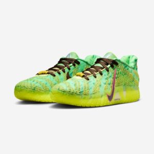 : A pair of glowing green Nike Ja 3 “Zombie” sneakers emerging from cracked concrete, their mesh veins illuminated in eerie light.
