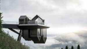 Cantilevered modern structure of the Heaven & Hell Spa at the Miramonti Boutique Hotel in South Tyrol, Italy, projecting dramatically over a mist-covered alpine valley, with sharp geometric lines and panoramic glass walls suspended above the landscape.