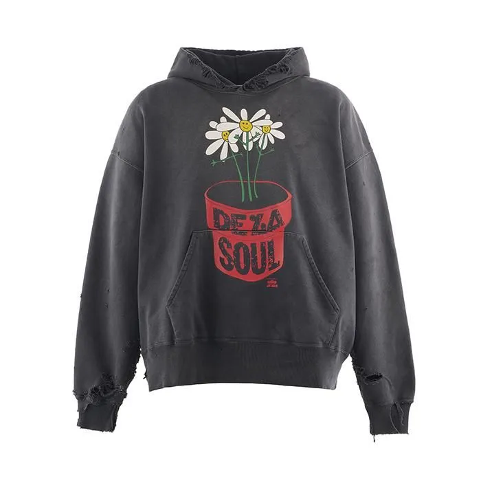 Front view of the SAINT Mxxxxxx x De La Soul “DLS_HOODIE” in black, featuring a distressed cotton body with a red flowerpot graphic containing three smiling daisies and the bold red text “DE LA SOUL.” The hoodie shows frayed cuffs, worn edges, and a vintage washed finish that reflects SAINT Mxxxxxx’s signature aged aesthetic.