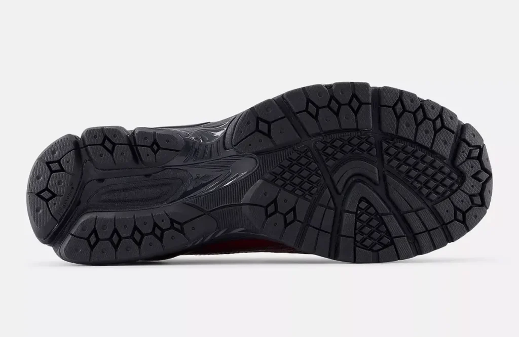 Bottom view of the New Balance 1906 LCS Loafer “Red Croc,” showing the black N-ERGY running outsole with segmented traction pods, flex grooves, and geometric rubber patterns designed for stability and cushioning