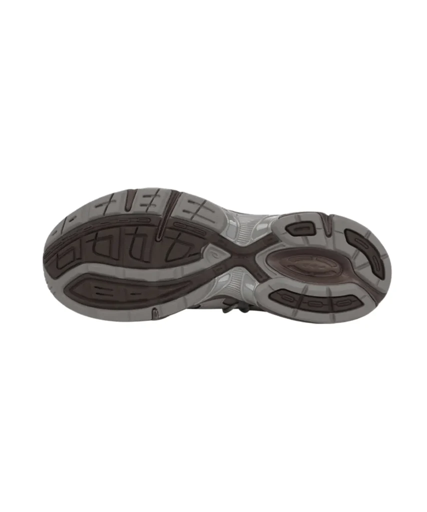 Bottom view of the OJOS x atmos Pink x ASICS GEL-1130 RE outsole, featuring a two-tone grey and dark brown rubber tread with segmented traction patterns, flex grooves, and a central ASICS logo embedded within the midfoot section. The design highlights durability and stability across the sole