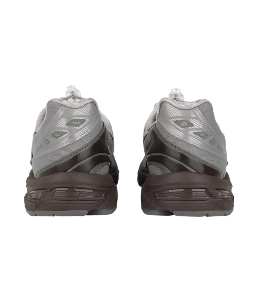 Rear view of the OJOS x atmos Pink x ASICS GEL-1130 RE sneakers, showing the layered grey mesh heel panels, reflective accents, and sculpted dark brown midsole. The clear lace toggles are visible at the top, highlighting the shoe’s technical and textural detailing