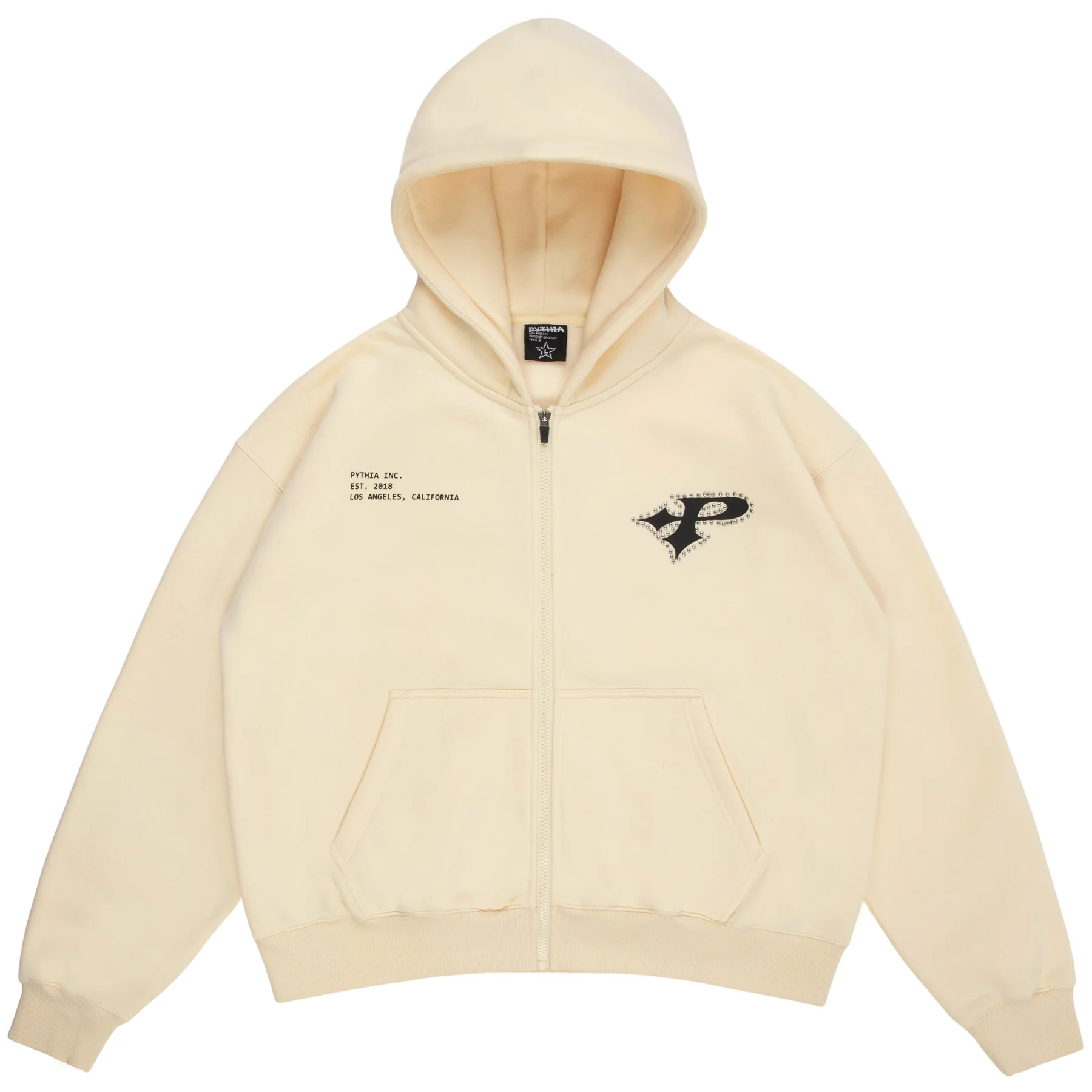 Cream zip-up hoodie from Pythia Inc. featuring a small studded black “P” logo on the left chest and minimalist printed text reading “PYTHIA INC. EST. 2021 LOS ANGELES, CALIFORNIA.