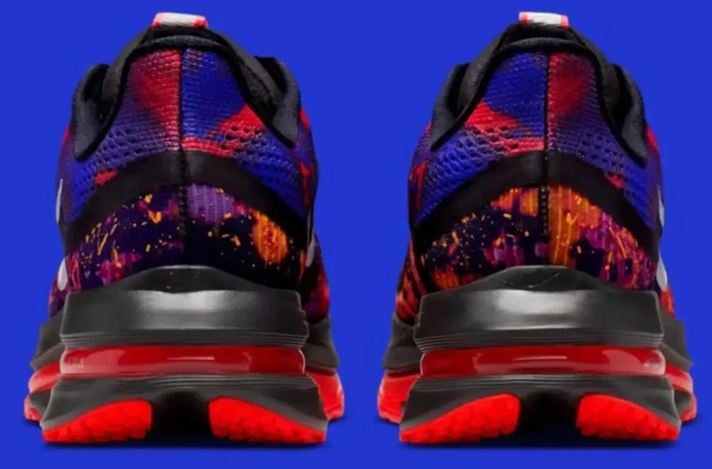 Rear view of the Nike Pegasus Premium “Bright Crimson,” highlighting the dual heel sections with vivid red midsoles, gradient purple and orange splatter-pattern uppers, and black accents, set against a solid blue background.