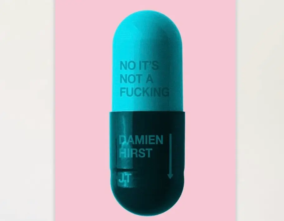 A turquoise and black capsule-shaped artwork set against a pale pink background, featuring the bold text ‘NO IT’S NOT A FUCKING’ on the upper half and ‘DAMIEN HIRST’ with a downward arrow and the initials ‘JT’ on the lower half