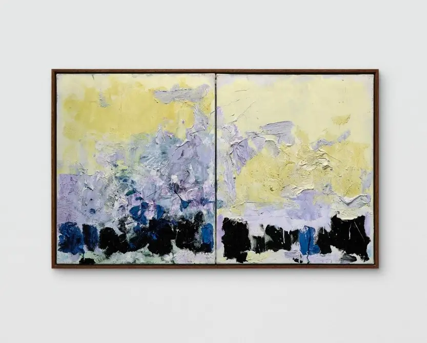 wo-panel abstract painting featuring layered strokes of pale yellow, soft lavender, icy blue, and deep black. Thick, textured paint forms an expressive landscape-like composition, with lighter hues billowing above darker, block-like shapes along the bottom edge. The artwork is framed in a slim brown wood frame and set against a neutral light-gray background