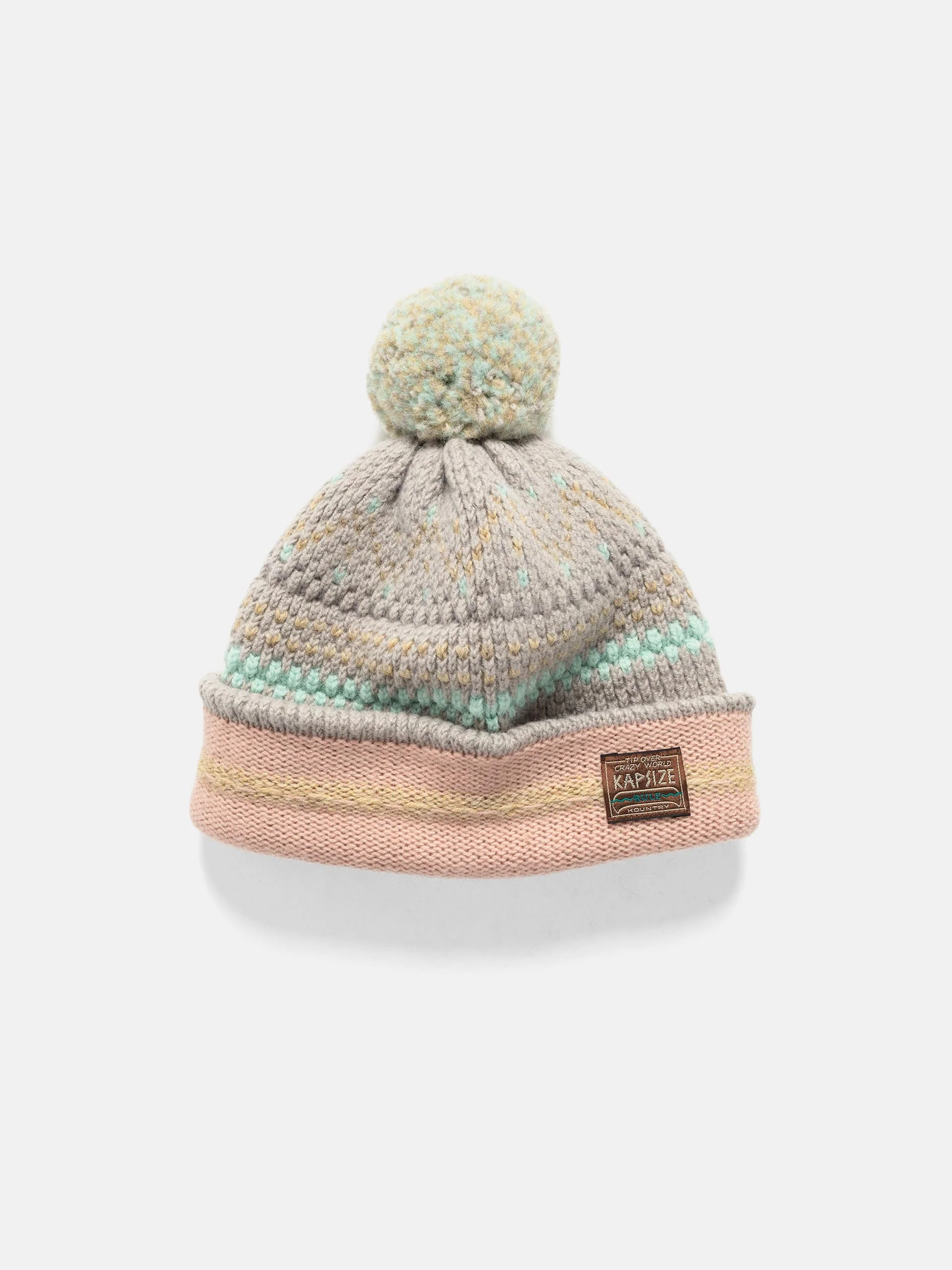 A KAPITAL 5G wool knit cap featuring a soft grey body with pastel yellow and mint speckled stitching, a large textured pom-pom on top, and a folded pink-and-grey brim accented with a small KAPITAL “Peace Activist” patch