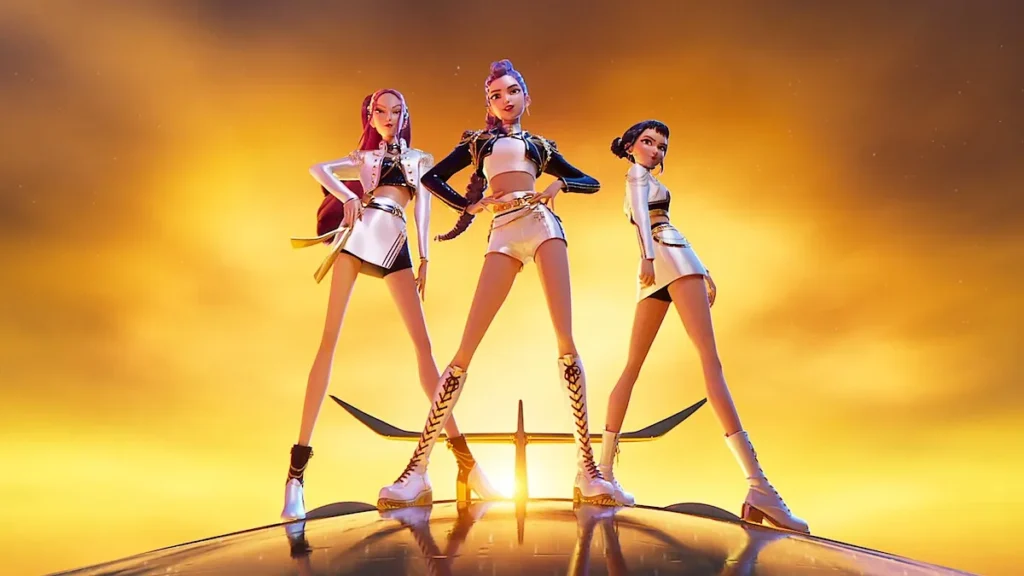Three animated K-pop idols stand confidently atop a sleek metallic surface against a glowing sunset sky. They wear futuristic silver and black stage outfits with platform boots, striking bold hero poses that emphasize power, unity, and attitude. The golden light and cinematic framing evoke the energy and glamour of KPop Demon Hunters