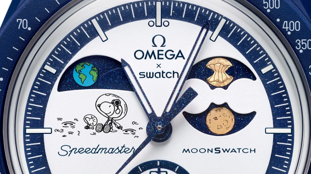 Close-up of the Swatch × OMEGA MoonSwatch Mission To The Earthphase – Moonshine Gold “Beaver Moon” dial, showing Snoopy sitting on the lunar surface with Woodstock beside him, the Earthphase display at left, and the moon-phase disc on the right featuring a golden moon partially shaped like a gnawed beaver log