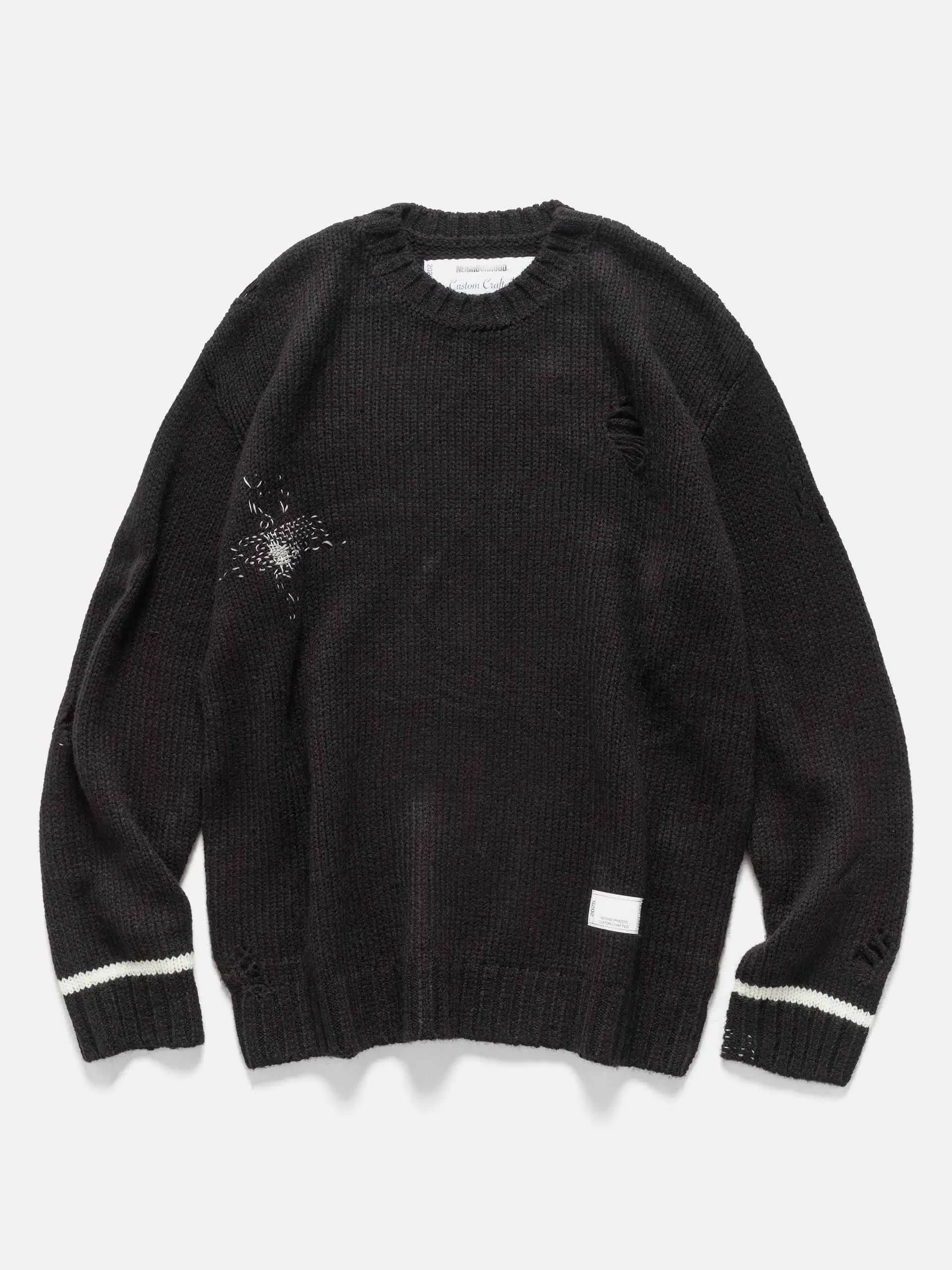 Front view of a black NEIGHBORHOOD Savage Crewneck Sweater featuring intentional distressing on the chest, shoulder, and sleeves, ribbed collar and hem, white stripe detailing on the cuffs, and a small woven label near the lower hem, laid flat on a light background