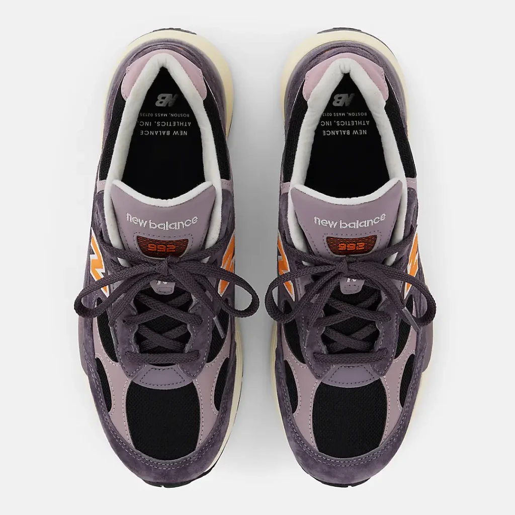Top-down view of the New Balance Made in USA 992 “Dark Ice Wine,” showing purple suede and lilac leather paneling, black mesh toe boxes, orange 992 tongue patches, and dark purple laces over cream midsoles