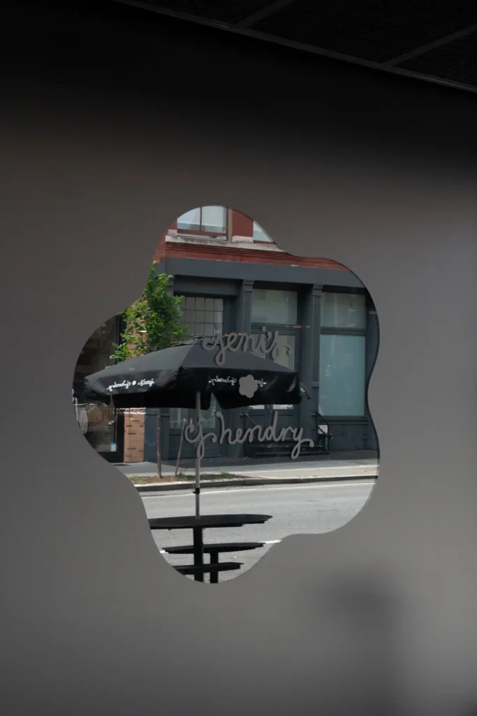 A jet-black ice cream cone photographed against a dark background, featuring two scoops of deep matte black ice cream with a matching waffle cone, highlighting smooth texture and minimal lighting for a monochrome, sculptural look