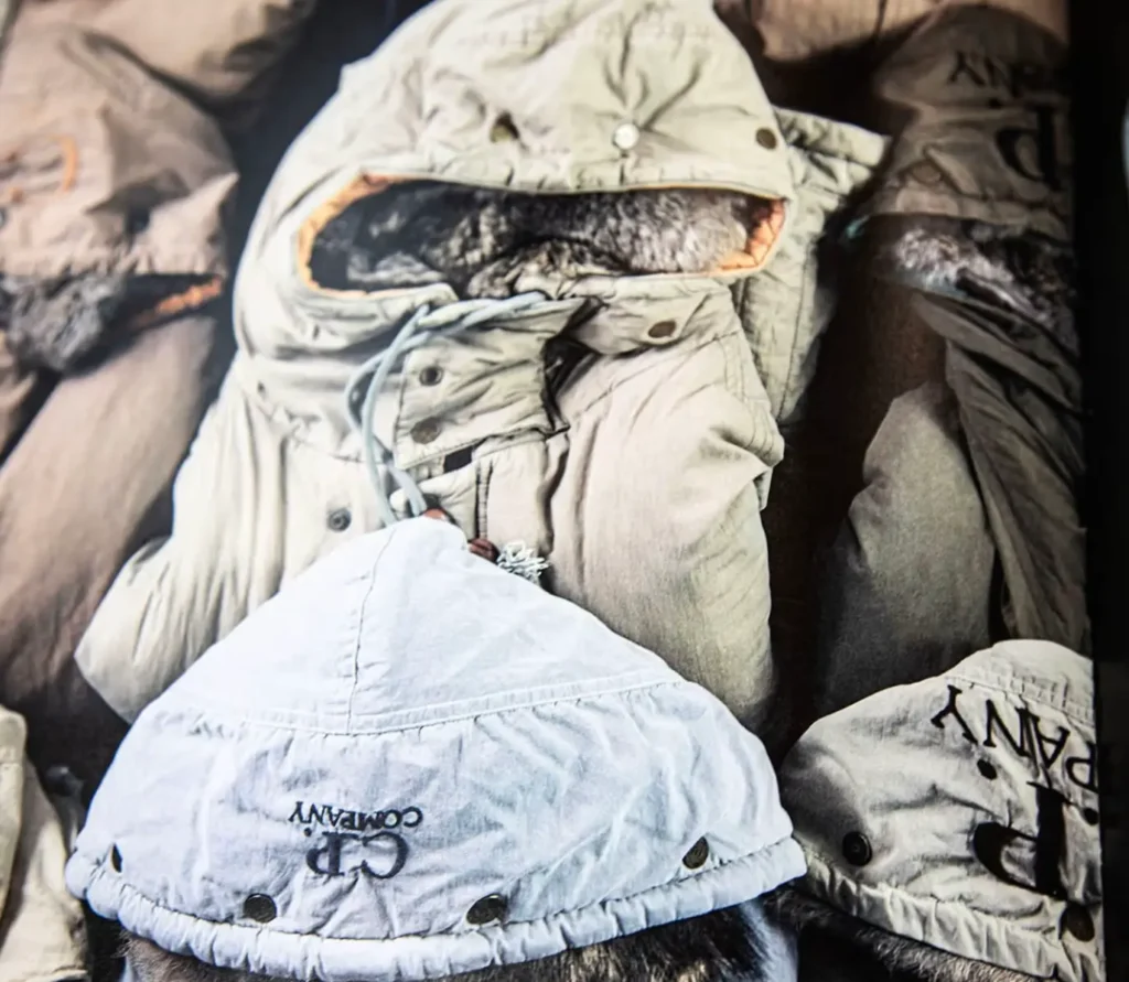 Close-up image from Counter Culture showing a collection of vintage C.P. Company jackets in muted tones, highlighting their signature goggle hoods, fur linings, and utilitarian detailing associated with UK terrace fashion