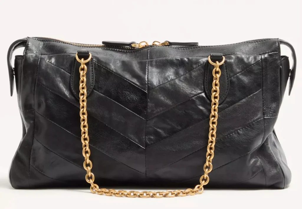 Rear view of the Valentino Garavani Panthea Shoulder Bag in black nappa leather with chevron stitching, featuring antique gold chain straps anchored to reinforced leather tabs and a smooth zip closure along the top, showcasing the craftsmanship and symmetrical chevron design across the back panel