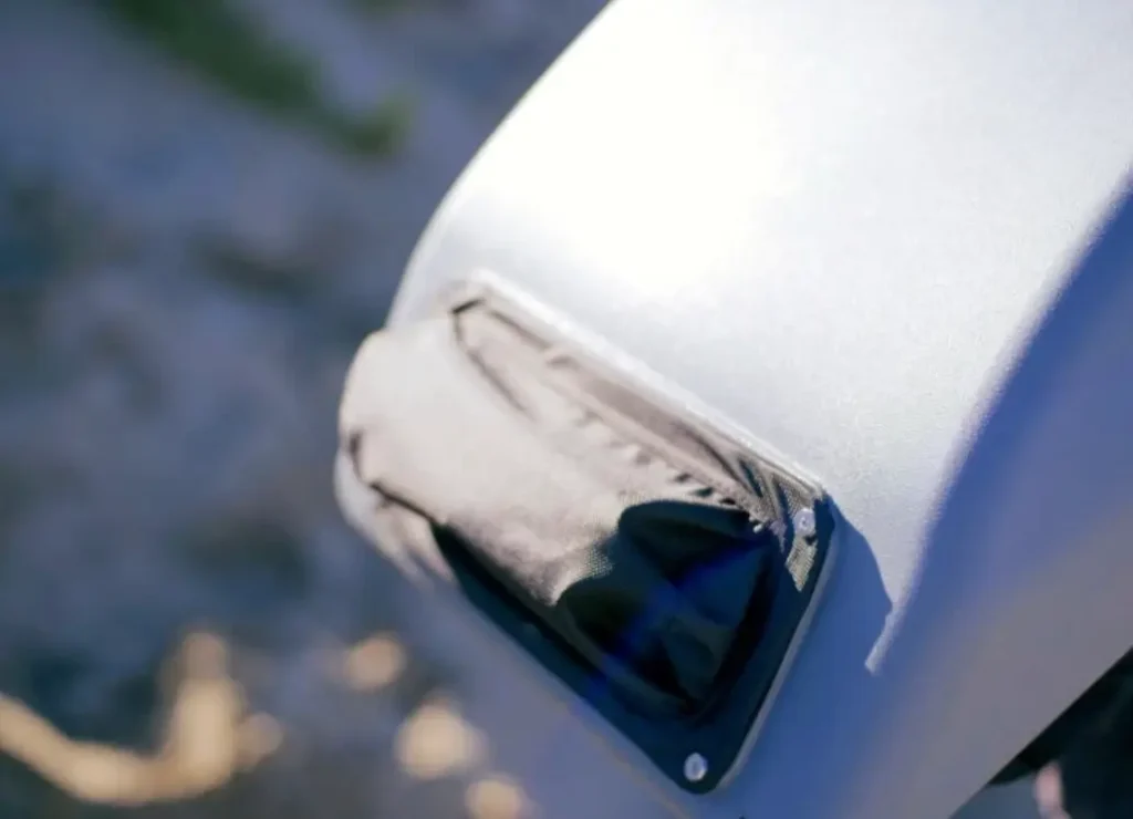 Acne Studios FW25 Holiday Gift Selection — a pair of light blue textured denim jeans neatly folded on a neutral backdrop, featuring the signature pink Acne Studios leather patch, symbolizing the brand’s clean and enduring Scandinavian craftsmanship