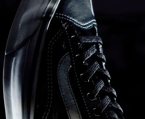 Close-up of the Vans OTW Old Skool 36 Vibram sneaker in black leather and canvas, highlighting the textured side stripe, metal eyelets, and detailed stitching under dramatic low lighting