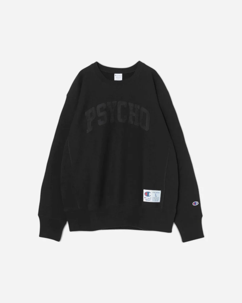 A black Undercover x Champion crewneck sweatshirt featuring tonal black “PSYCHO” lettering across the chest, with a Champion woven label near the hem and an embroidered “C” logo on the sleeve