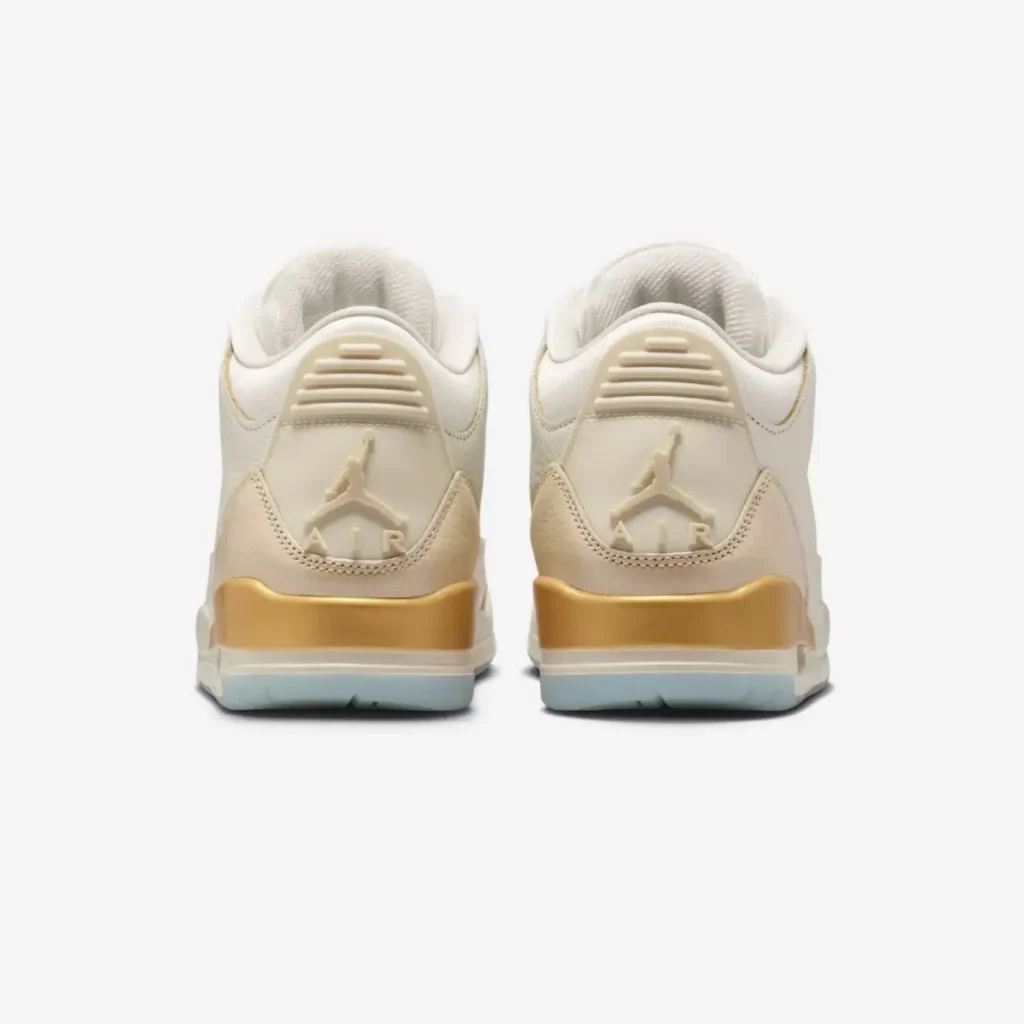 Rear view of the Air Jordan 3 “Champagne & Oysters,” featuring cream heel tabs with embossed Jumpman logos, smooth beige panels, metallic gold midsole accents, and icy translucent outsoles against a white background