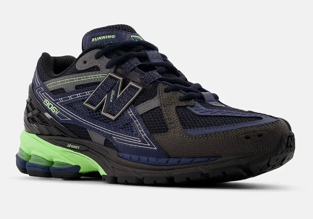 New Balance 1906U ‘Eclipse’ sneaker featuring dark navy mesh, charcoal overlays, reflective detailing, and a neon green N-ERGY midsole accent, shown at a three-quarter angle on a light background
