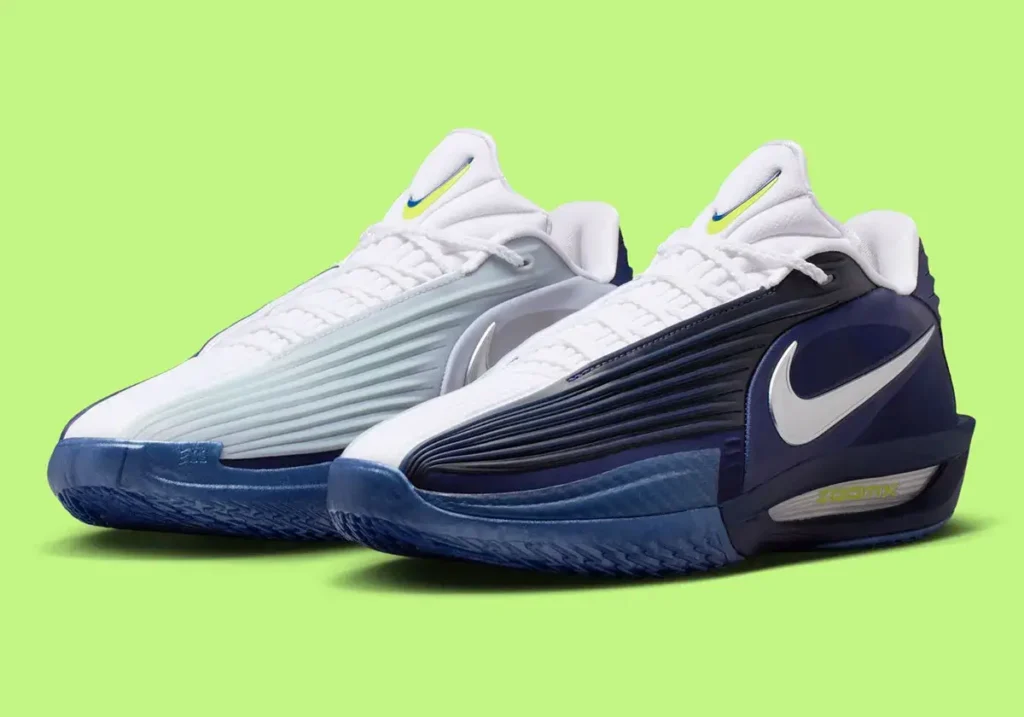 A pair of Nike GT Cut 3 Turbo sneakers in a Dallas Mavericks-inspired colorway, featuring asymmetrical navy and ice-blue uppers with white woven tongues, metallic silver Swooshes, and translucent blue outsoles, photographed against a bright lime-green background