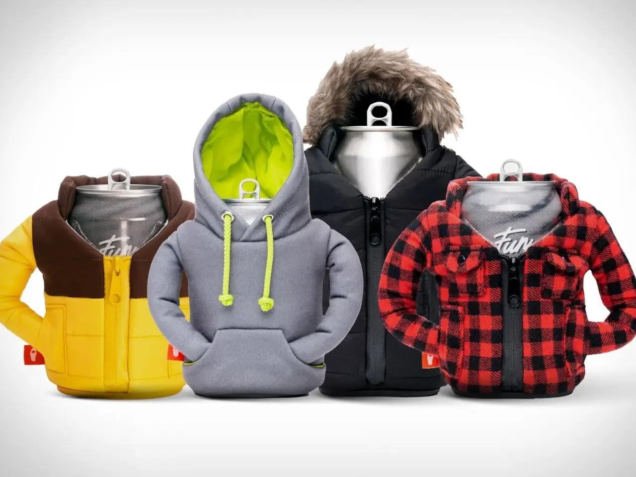 A lineup of beverage cans dressed in miniature Puffin Drinkware outfits, including a yellow puffer jacket, a grey hoodie with neon lining, a black parka with faux fur hood, and a red-and-black plaid flannel jacket. Each insulated holder mimics real winter outerwear with zippers, pockets, and detailed stitching