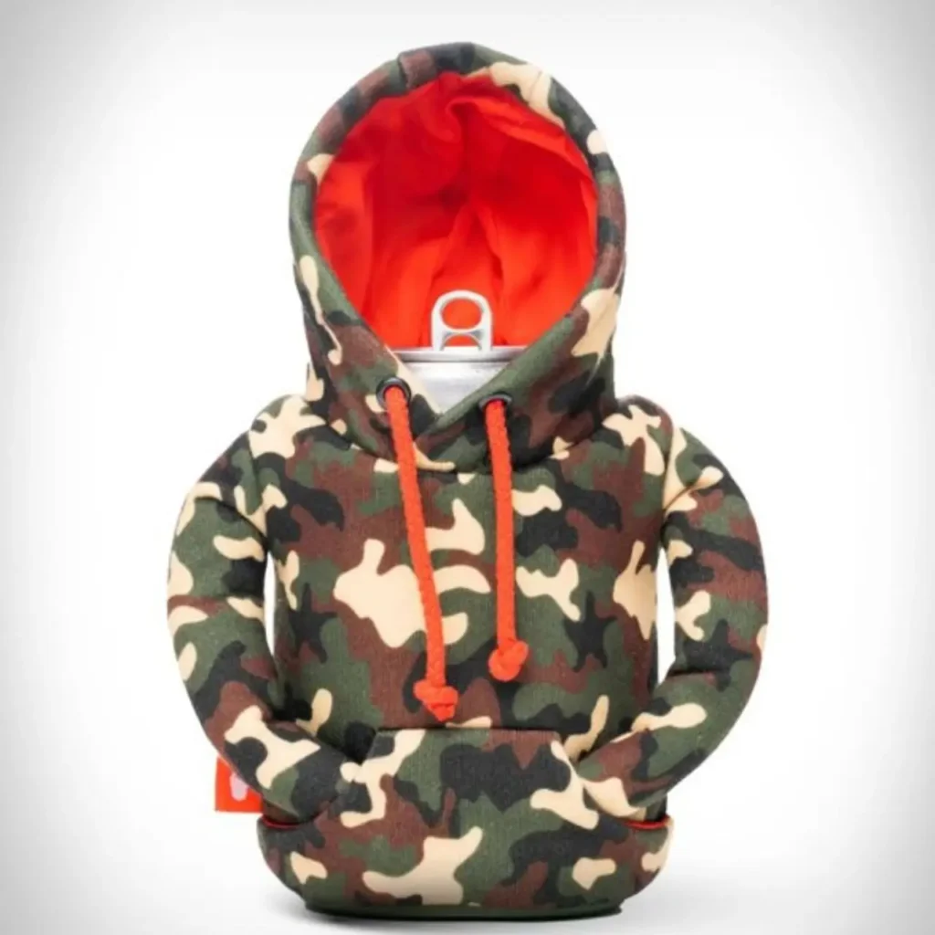 A beverage can wrapped in a Puffin Drinkware holder styled like a camouflage hoodie, featuring a green-and-brown camo pattern, bright orange drawstrings, and a vivid orange inner hood lining, mimicking a cozy streetwear pullover
