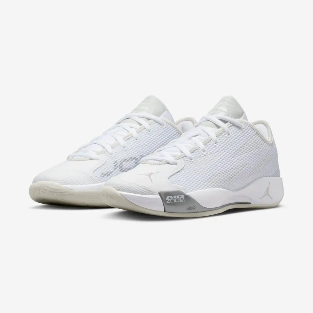 A pair Jordan Luka .77 “Pure Money” basketball shoes in an all-white colorway, featuring a low-top silhouette with breathable mesh upper, subtle Jumpman branding, and visible Air Zoom cushioning on the midsole, shown from a three-quarter front angle on a clean white background