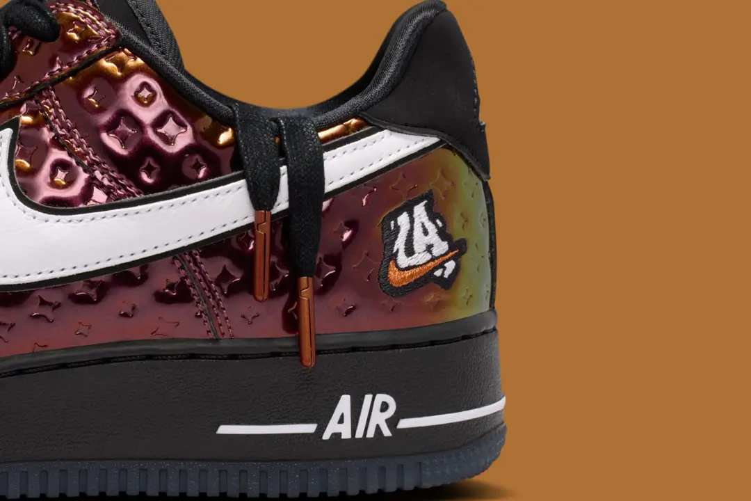 Nike Air Force 1 Low PRM “LA All-Star” sneaker close-up featuring iridescent embossed leather upper, white Swoosh, black midsole with AIR branding, copper lace tips, and “LA 24” embroidered patch detail
