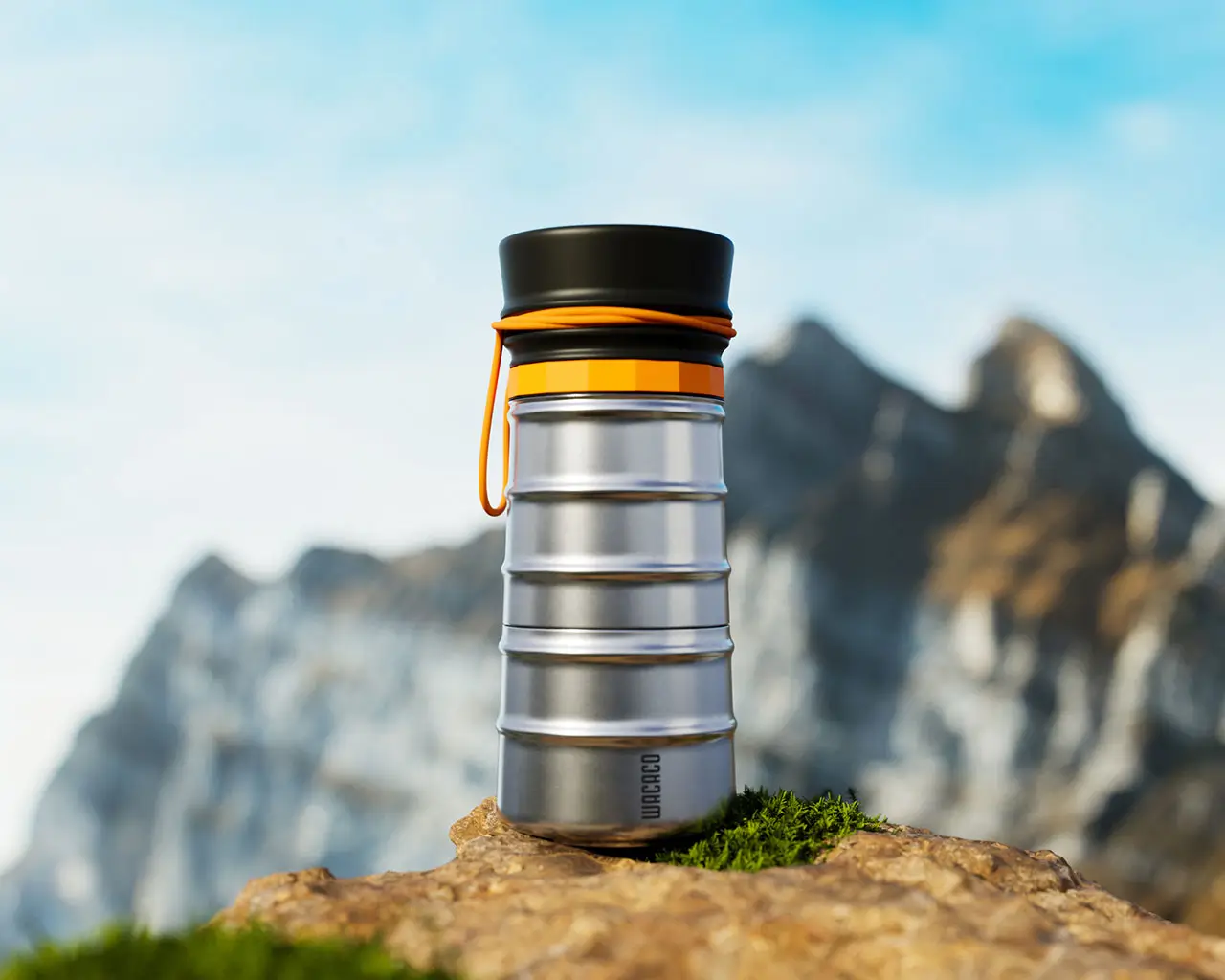 MokaMax Instant Coffee Pot shown outdoors on a rock, featuring a compact stainless-steel body with ribbed detailing, black lid, and orange accent strap against a mountain landscape background.