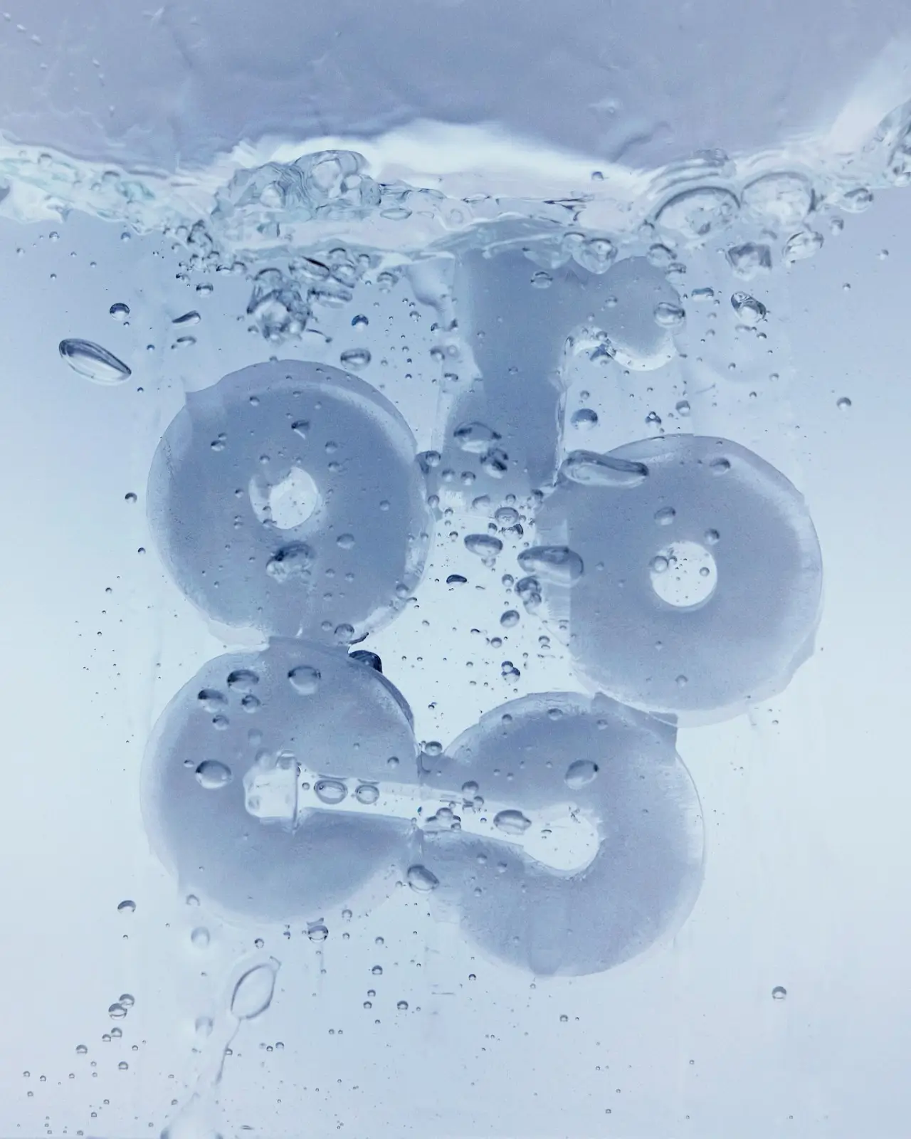 Ice-blue abstract cooling elements submerged in water with air bubbles rising, representing the Rocco super smart fridge’s advanced cooling technology and clean, modern aesthetic