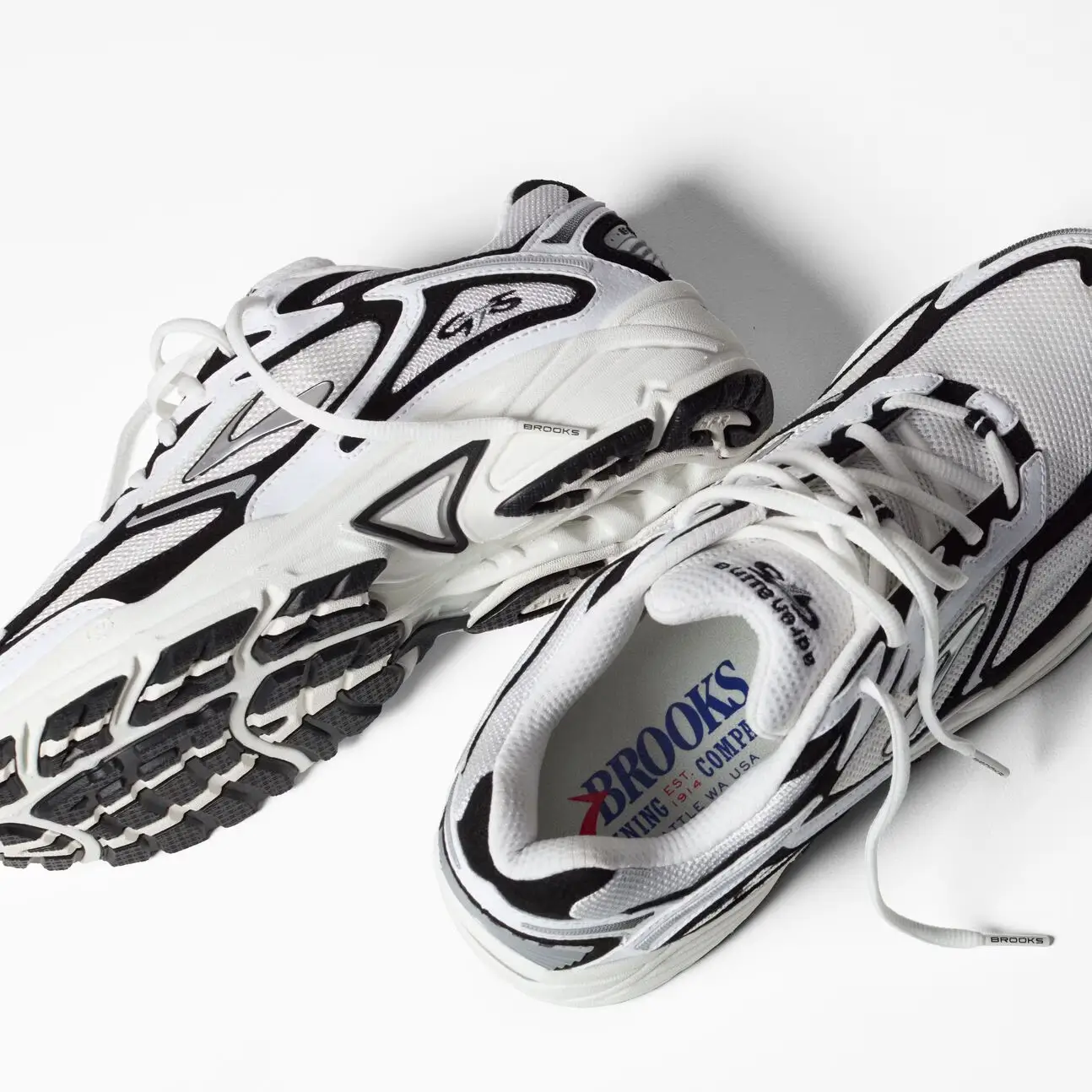 Brooks Adrenaline GTS 4 men’s running shoes in white and black shown as a pair with outsole traction and mesh upper details