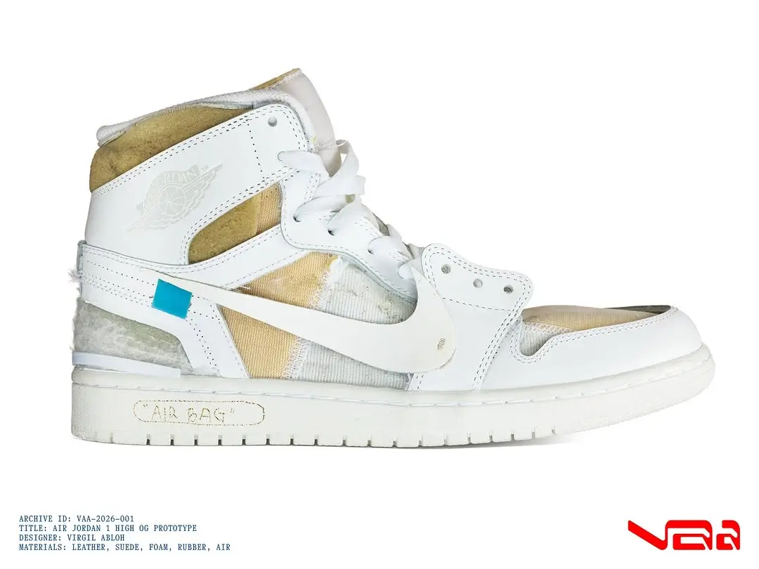 Side profile of Virgil Abloh’s Air Jordan 1 High OG “Alaska” prototype featuring a white leather upper, exposed foam collar, visible stitching, detached Swoosh with blue tab, and “AIR” branding on the midsole