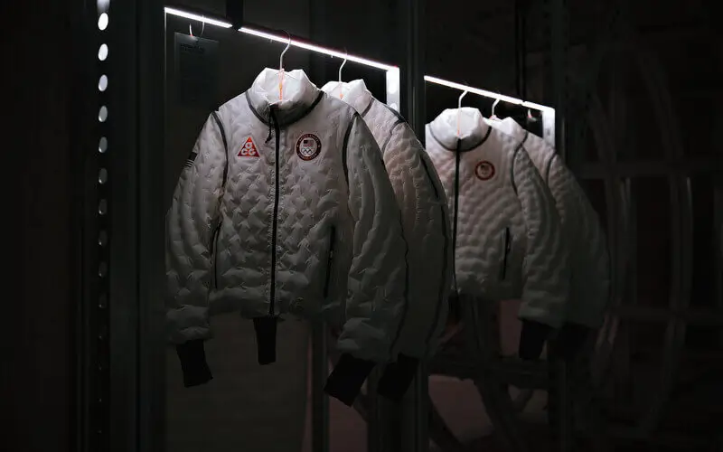 Nike Unlimited Air Milano inflatable jackets displayed on illuminated racks inside a dark exhibition space showcasing Nike’s experimental Air apparel design