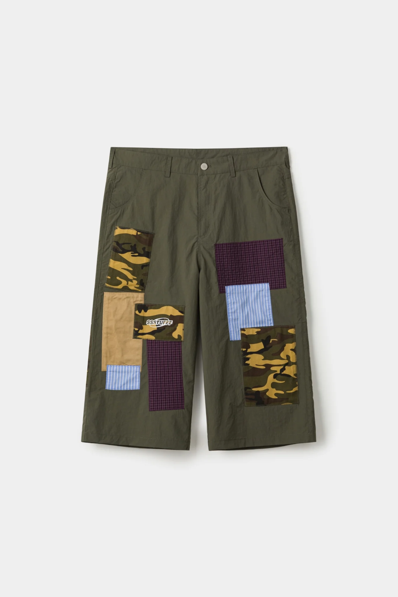 Olive SSSTUFF patchwork shorts featuring asymmetrical camo panels, burgundy grid fabric, khaki block, and blue striped inserts across a relaxed knee-length silhouette with visible stitched construction