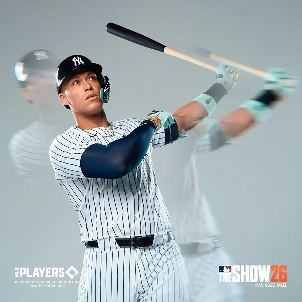 Baseball player in a New York Yankees pinstripe uniform captured mid-swing with motion blur trails, wearing a black helmet and batting gloves, against a clean studio background with MLB The Show 26 branding visible