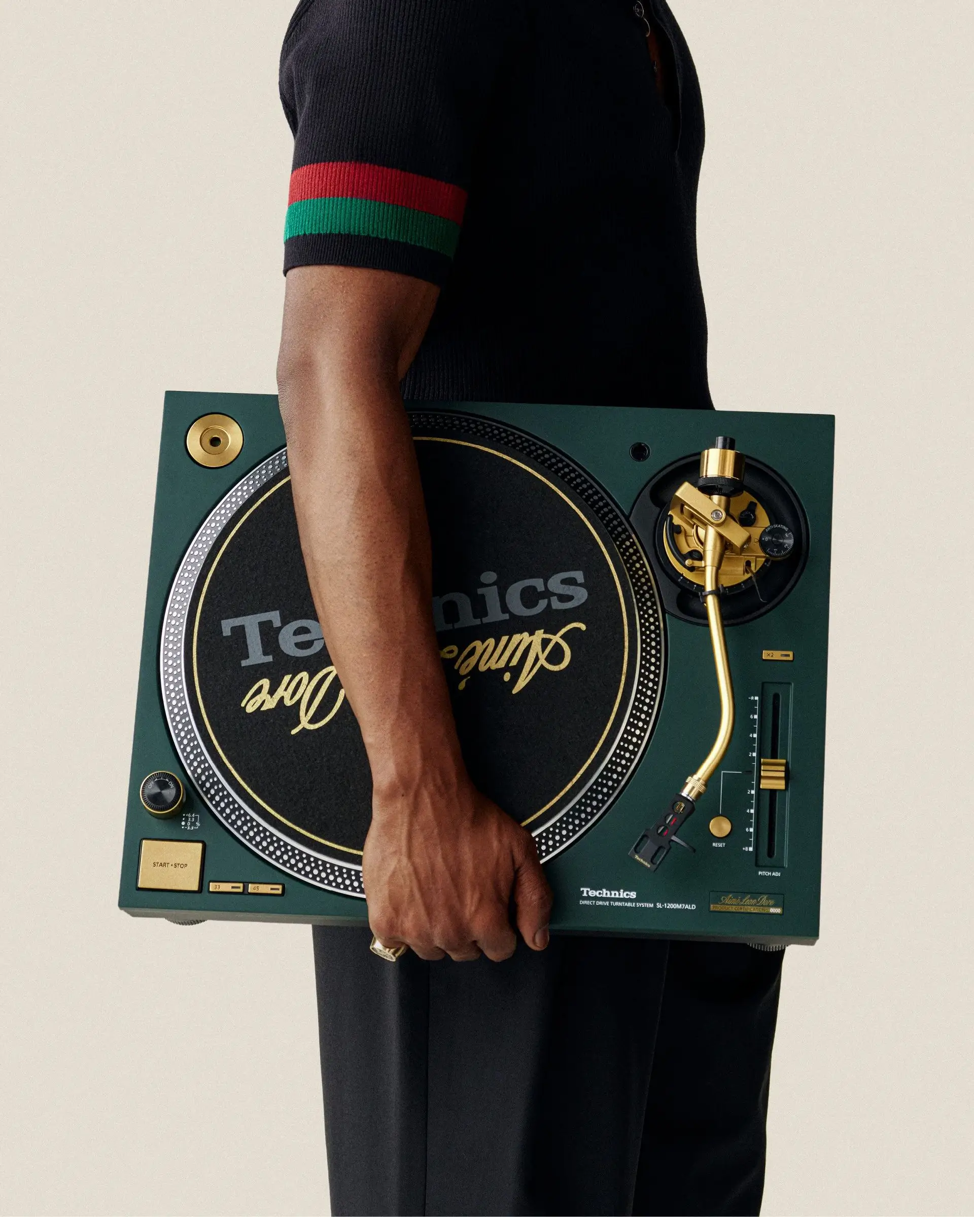 Model holding Aimé Leon Dore Technics turntable featuring premium materials and minimalist design