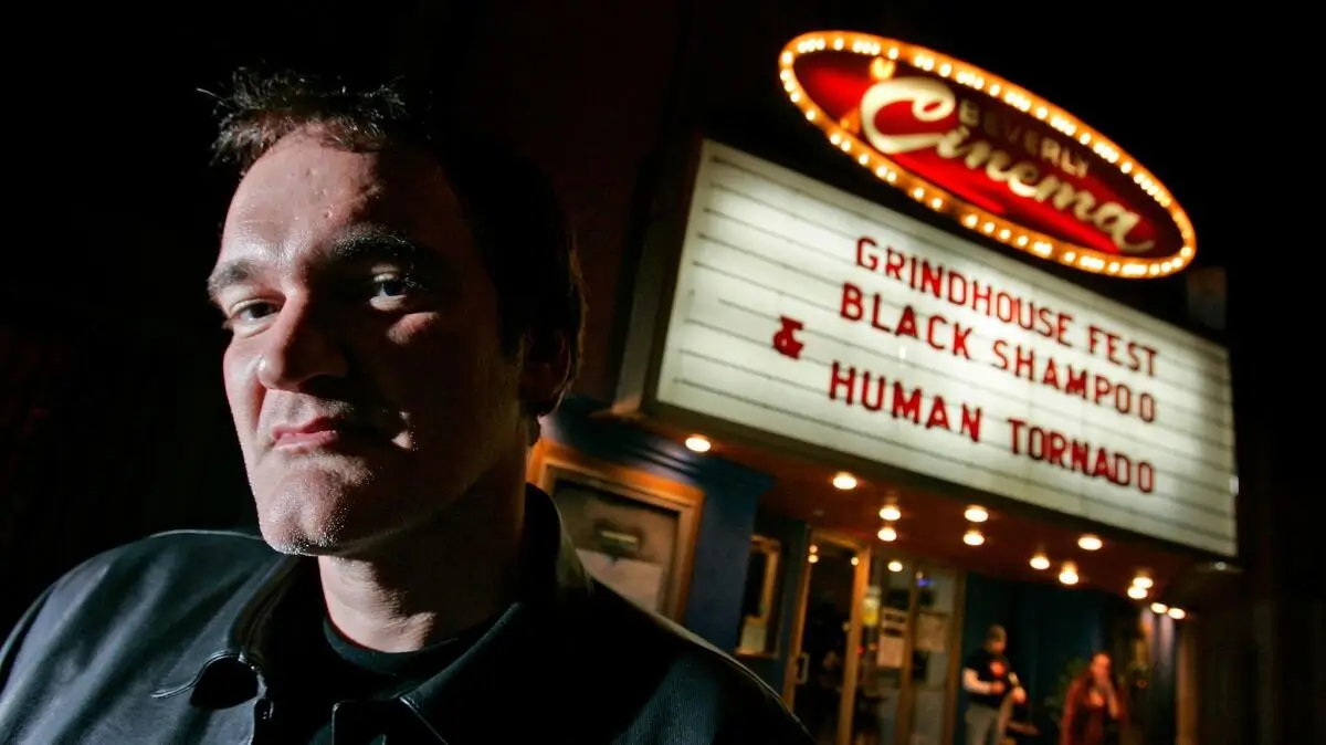 Film director standing outside the New Beverly Cinema at night beneath a marquee reading “Grindhouse Fest – Black Shampoo & Human Tornado”