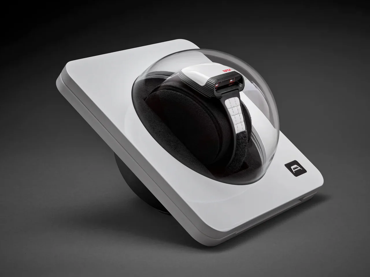 AMIDA Digitrend NASA edition watch displayed inside a futuristic white presentation case with a transparent dome cover, resting on a black cushion, highlighting its prism-style digital display and quilted technical strap