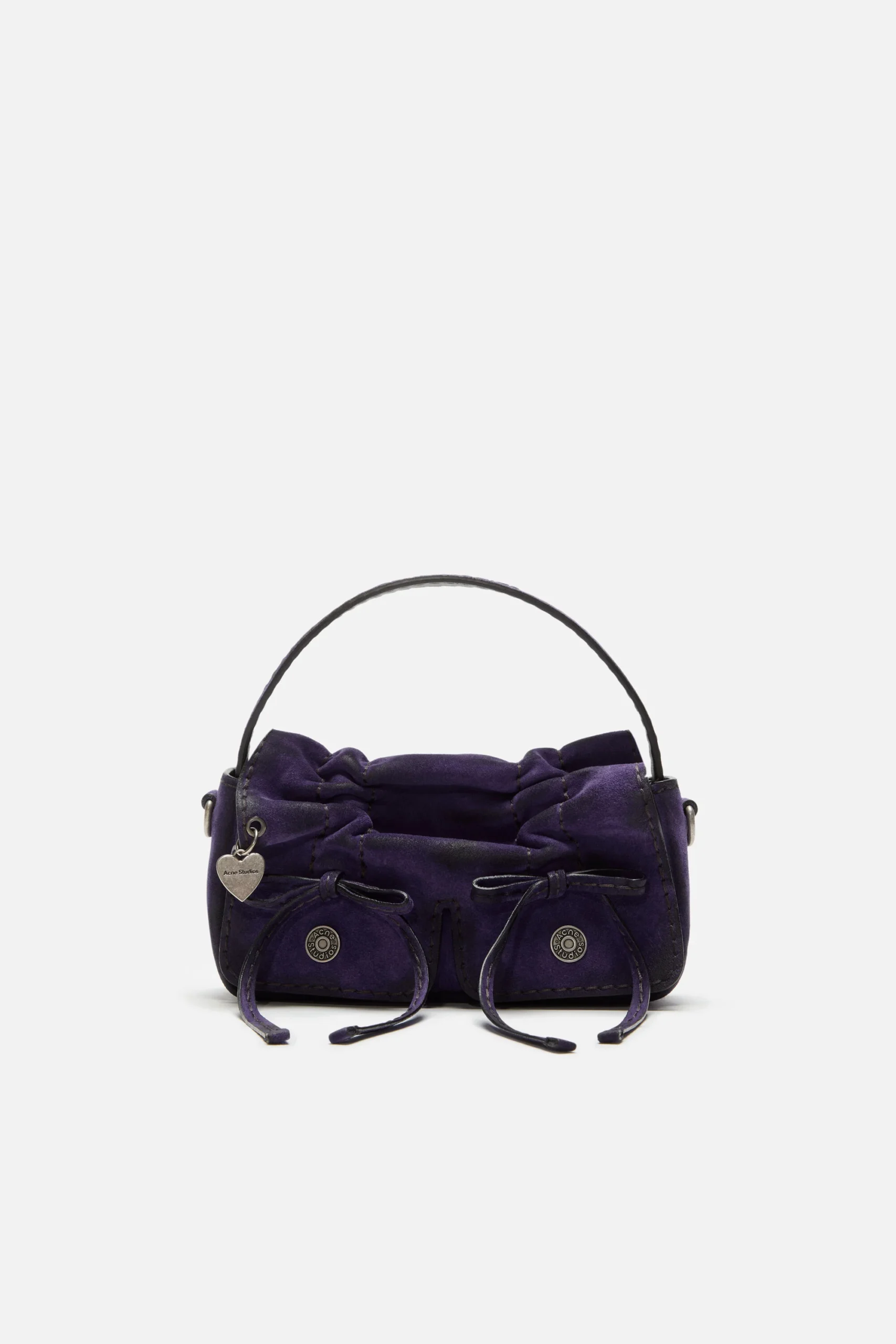 Violet purple Acne Studios multipocket micro bag in a compact rectangular silhouette, featuring gathered leather detailing, two front flap pockets with drawstring ties, subtle metal logo buttons, and a small heart-shaped charm on the side. The bag has a structured top handle in black leather and a softly textured finish, presented against a clean white background