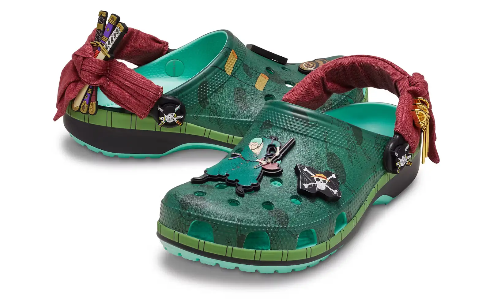 ONE PIECE x Crocs Classic Clog inspired by Roronoa Zoro featuring green Croslite foam upper, sword-themed Jibbitz charms, and red bandana heel straps referencing the Straw Hat Pirates swordsman