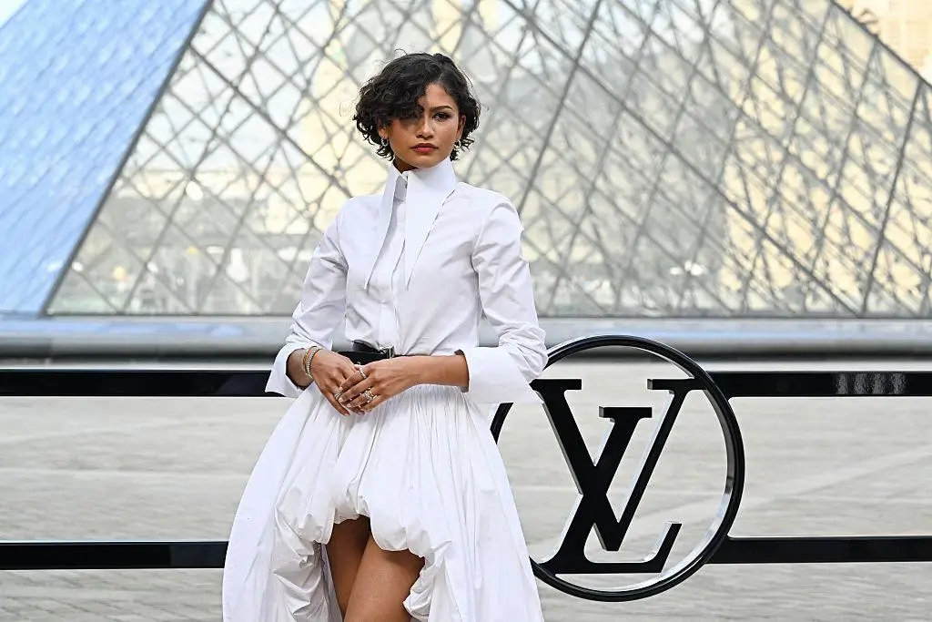 Zendaya wearing a white Louis Vuitton bubble dress with a black belt and Cartier jewellery outside the Paris Fashion Week show at the Louvre