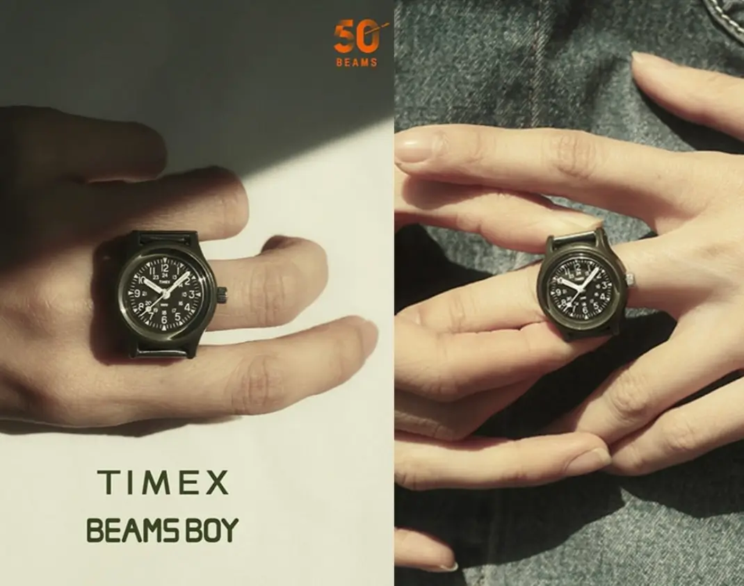 TIMEX BEAMS BOY ring watch worn on finger featuring black military-style dial and compact case with 50th anniversary branding