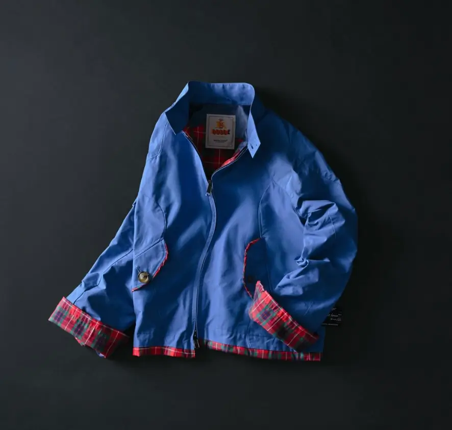 BARACUTA x UNDERCOVER blue swing top jacket from SS26 “but beautiful 6…” collection featuring red tartan lining, cropped silhouette, and minimalist zip-front design