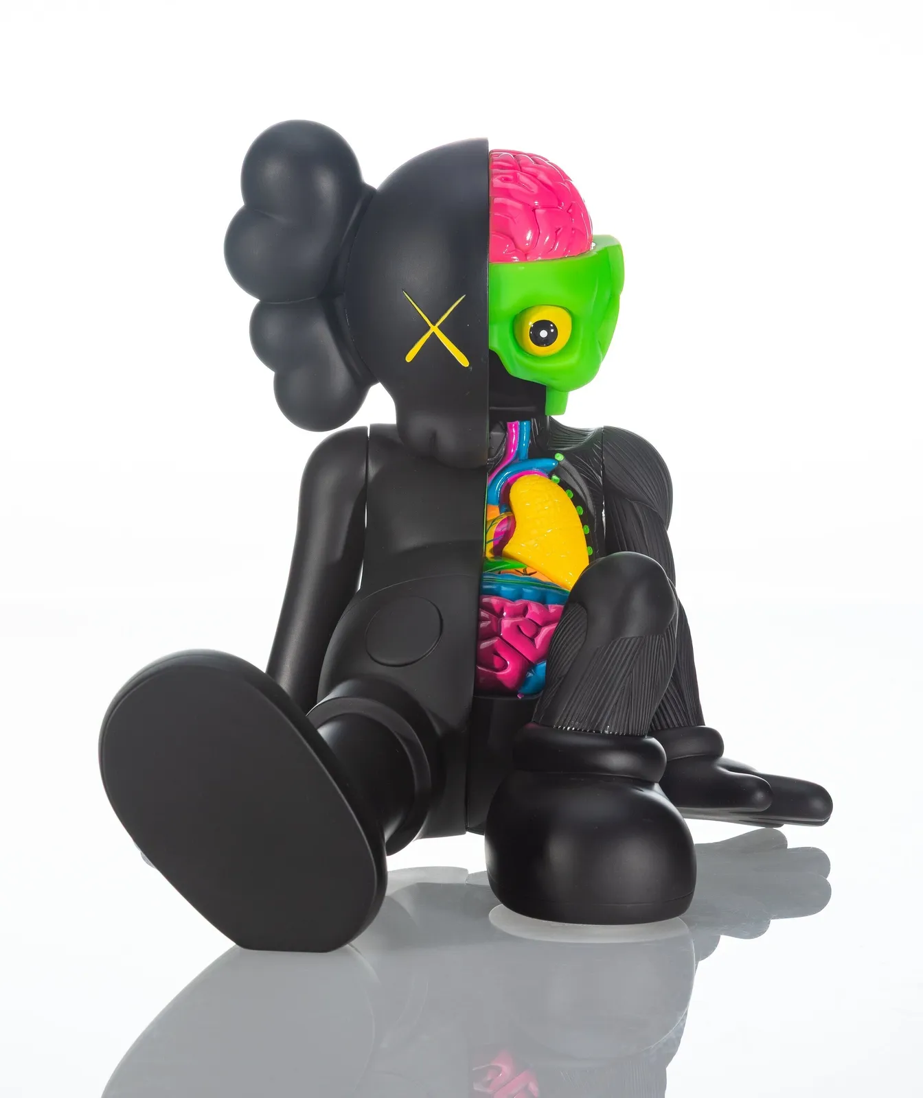 KAWS Companion dissected figure sculpture showing half matte black exterior with XX eye and half exposed colorful anatomy including brain, organs, and skeletal detailing