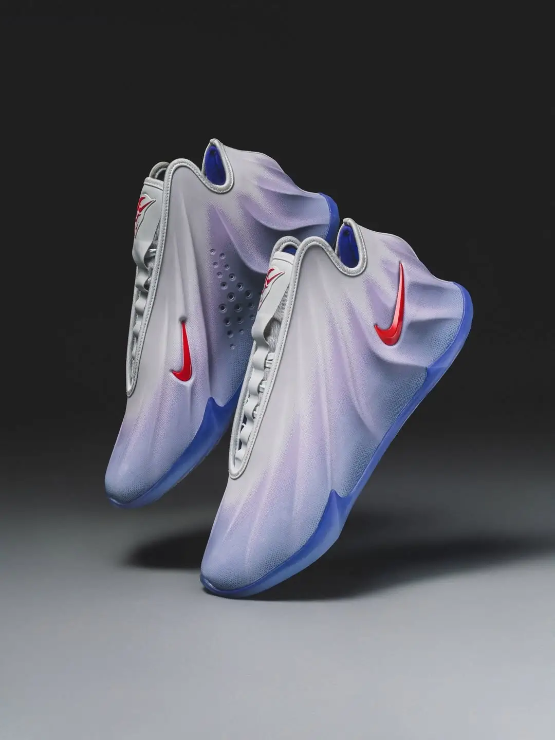 Nike G.T. Future basketball shoes in a sculptural, futuristic design featuring a seamless white-to-blue gradient upper, glossy red Swoosh logos, and a translucent blue sole, shown in a floating studio composition against a dark background