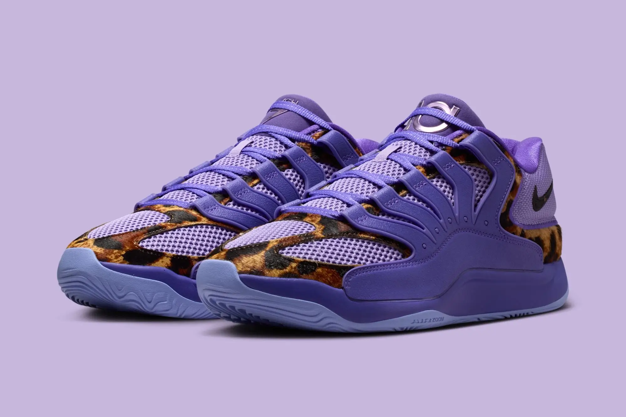 Three-quarter view of the Chet Holmgren x Nike KD 18 PE “Thunder & Reign” basketball sneakers featuring a purple mesh upper, sculpted lace cage, leopard-print overlays along the mudguard, black Swoosh branding, and light lavender outsole